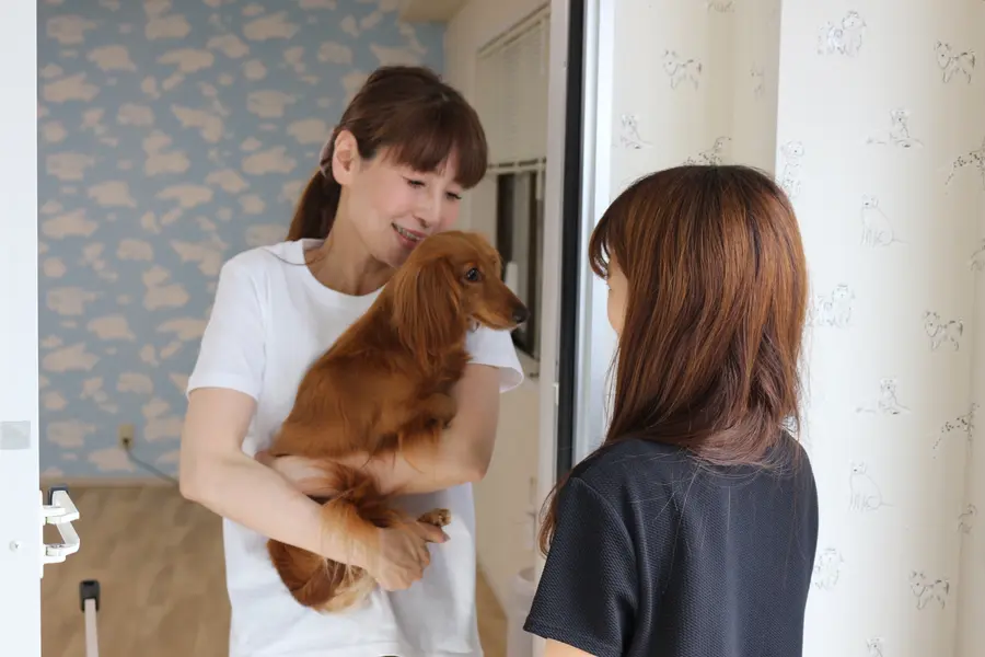 お迎え時に飼い主さまへ一日の様子を伝えるオーナー